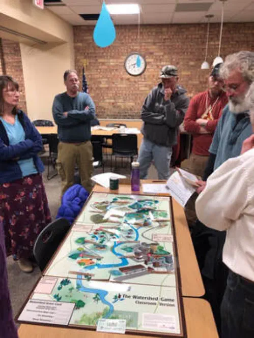 Watershed awareness game board Watershed awareness game board surrounded by players
